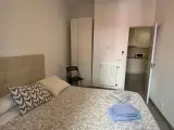 Segundo dormitorio doble con colcha de corazones, toallas amarillas y rosas y ventana al jardín